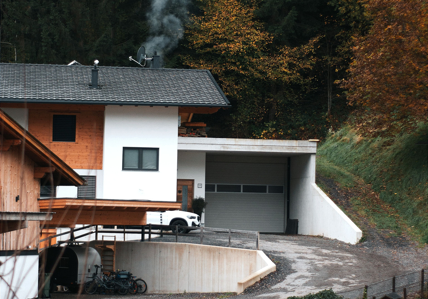 Tiroler Wohnhaus mit Zufahrt, Hanglage und sichtbarem Grundstücksumfeld
